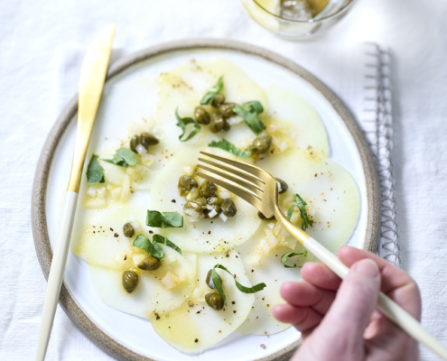 Dünn geschnittenes Kohlrabi-Carpaccio mit Kapern und Kräutern.
