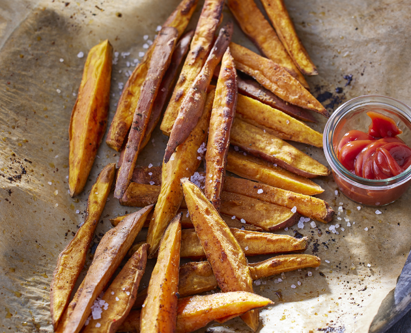 Knusprige Süßkartoffelpommes mit Meersalz und Ketchup.